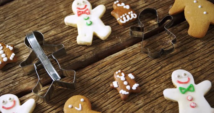 Cookie cutter and gingerbread cookies on wooden plank 