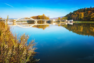 Fototapeta na wymiar Bridge in Piestany (Slovakia), Vah river, blue sky, colorful autumn
