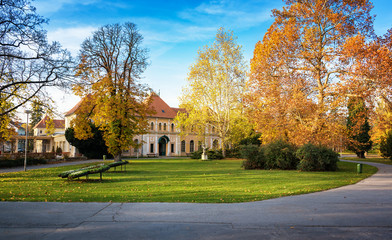 Fototapeta premium Autumn in Piestany (Slovakia) – park, historical building, colorful trees, blue sky