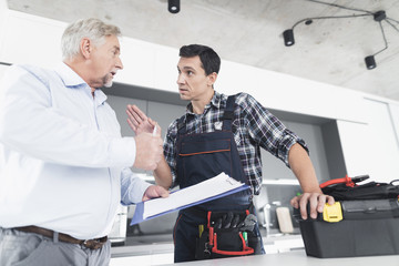 The plumber man communicates with the client and shows him the account for the work done.