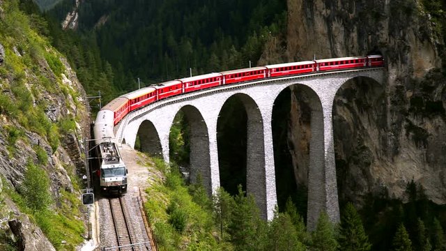 The train passes through the famous Landwasser viaduct in Switzerland. Top view.