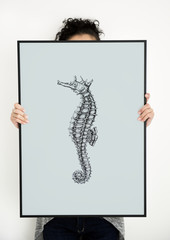 Woman holding hand drawing seahorse picture in photo frame © Rawpixel.com