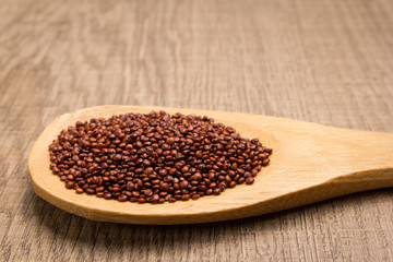 Red Quinoa seed. Grains in wooden spoon. Rustic.