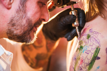 Professional tattoo artist during working process