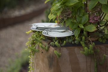 Nachmittags Kaffee im Garten, Teller auf Blumentopf abgestellt vor dem Regen geflogen