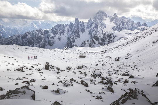 Hikers along the path in Tre Cime Natural Park, in the background the Cadini peak, dolomites, Italy