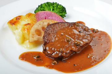 Close up of beefsteak with sauce on white plate