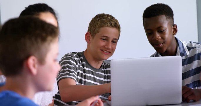 Schoolkids using laptop in classroom 