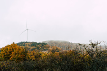 Wind power generator in mountain with fog