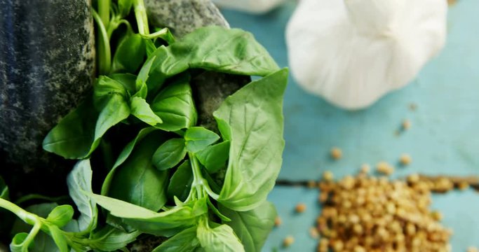 Mortar and pestle with herbs and spices on wooden table 