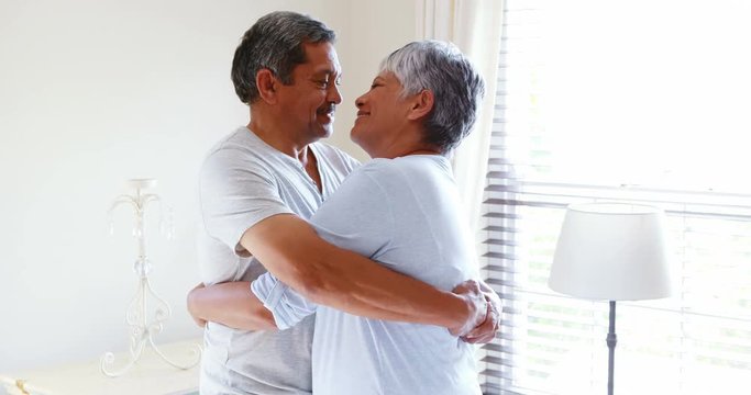 Senior couple embracing each other in bedroom 
