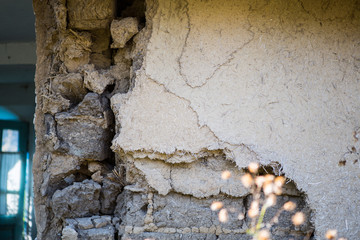 Fototapeta premium Part of Ruined old house. Ruins of a house made of shell rock, straw and clay in the village. Poor old village.