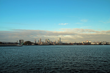 Fototapeta premium Rotterdam skyline on the horizon with big cloud front above it with blue sky