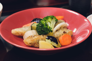 Cod fish and vegetable fried mix sauce in dish red color