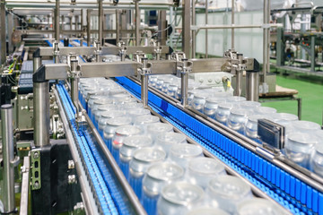 Packed cans on the conveyor belt in berverage factory