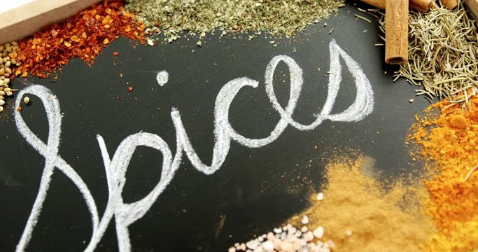 Word spices written on slate with various spices 