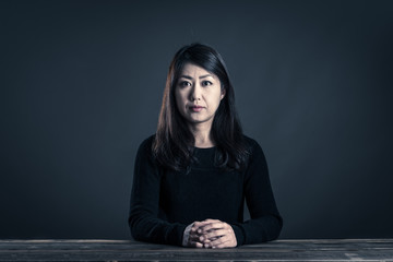 座っている女性 暗いイメージ