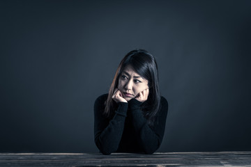 座っている女性 暗いイメージ