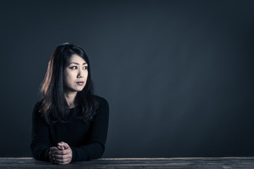 座っている女性 暗いイメージ