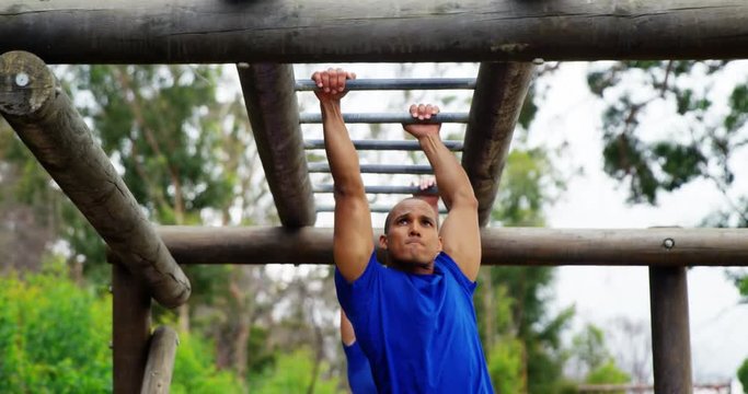 Fit man climbing monkey bars 