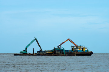 Fototapeta premium Machines are dredging sand in the sea.
