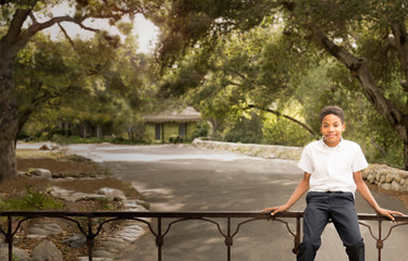 Fototapeta na wymiar Happy Black African American boy sitting on iron gate