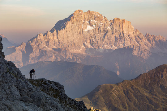 Man photographing Mount Civetta, at sunset, Dolomites, Italy
