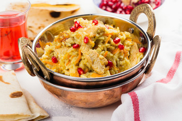 Pilaf with meat, spices and pomegranate seeds. Traditional dish of Asian cuisine