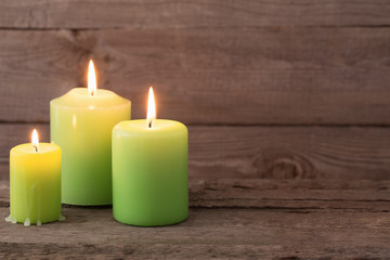 Obraz na płótnie Canvas green candles on dark wooden background