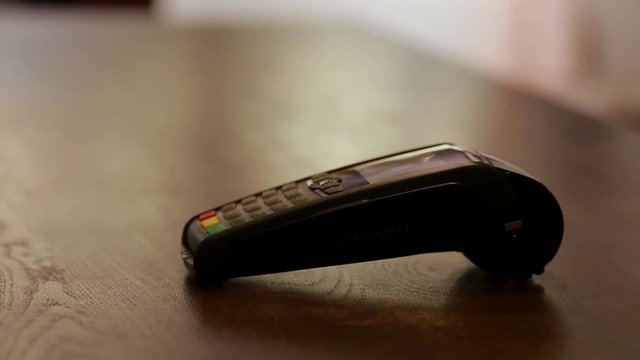 Man paying with NFC technology on mobile phone, restaurant, shop.