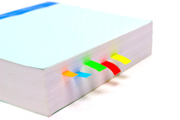 Closeup Book with multicolors bookmarks on white table