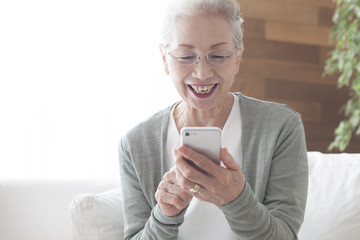 An old lady is absorbed in smartphone