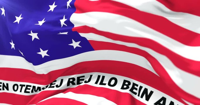 Flag of Bikini Atoll, member of the Marshall Islands, waving at wind in slow with blue sky, loop