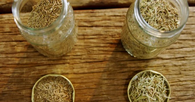 Spices in jar and lid on wooden table 