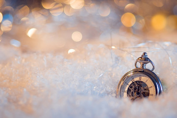 New year, almost midnight. Festive background, antique clock in the snow