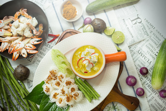 Curry crab, Seafood with Yellow curry sauce in orange ceramic pot, on tablecloths background