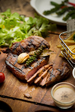 T-Bone Beef Steak on wooden board.  Beef Steak Dinner and French fries