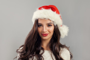 Christmas Woman Model wearing Red Santa Hat with on Banner Background. Brunette Woman Christmas Concept