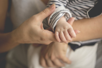 Obraz na płótnie Canvas Newborn baby lying in her mother's arms