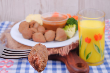 Meatballs with cucumber, carrot, brocolli, black pepper sauce , mashed potato and  corn juice over wooden table. Healthy eating concept.
