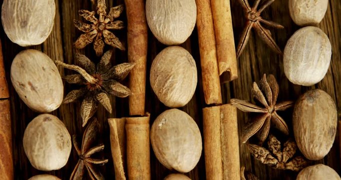 Nutmeg, star anise and cinnamon sticks arranged on wooden table 