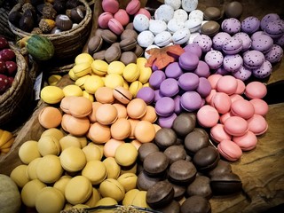 Colorful french macarons in the street market background, close up.Different colorful macaroons background.Tasty sweet color macaron,Bakery concept.Selective focus.