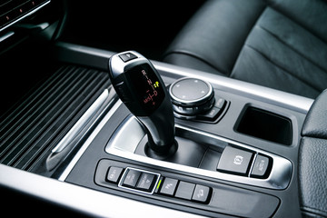 Automatic gear stick (transmission) of a modern car, multimedia and navigation control buttons. Car...