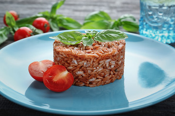 Plate with delicious brown rice on table