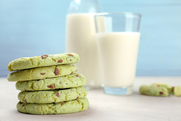Fresh mint chocolate chip cookies and milk in glassware on table