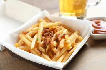 Box with french fries and bacon on table