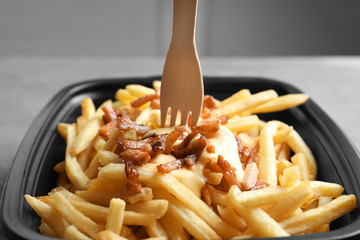 French fries with bacon and cheese in box, closeup