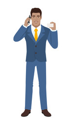 Obraz premium Businessman talking on the mobile phone and showing the business card