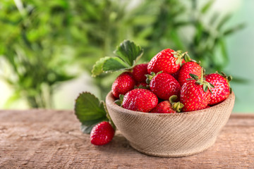 Fresh ripe strawberries in bowl on table