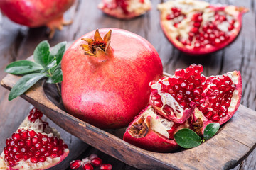 Ripe pomegranate fruits on the wooden background.
